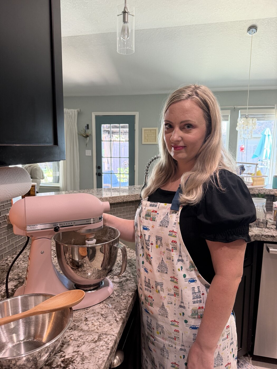 Bethany baking in her Paris-themed apron beside her pink mixer